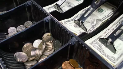 Close-up of cash drawer with various dollar bills and coins.