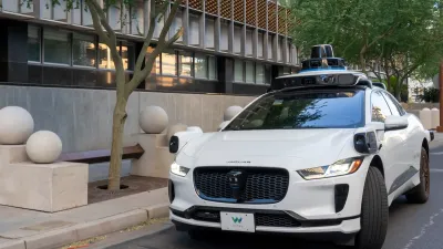 White self-driving Waymo vehicle on street in Phoenix, Arizona.