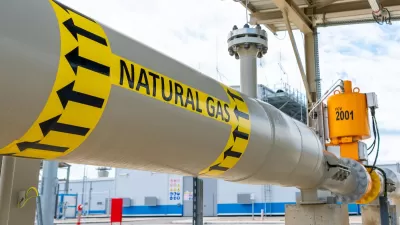 Close-up of pipe labeled with yellow and black Natural Gas sticker.