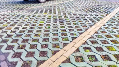 Close-up of green permeable street with concrete lattice over soil and grass.