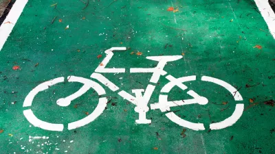 White bike symbol painted on green bike lane.