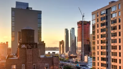 View of high-rise buildings and construction cranes in midtown Manhattan against sunset sky