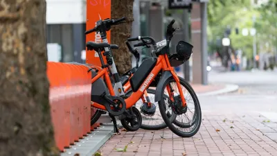 Orange Biketown bike share bikes parked at station on sidewalk in Portland, Oregon,