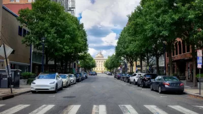 Crosswalk on street in Raleigh, North Carolina with parking on both sides and capitol building visible in background.