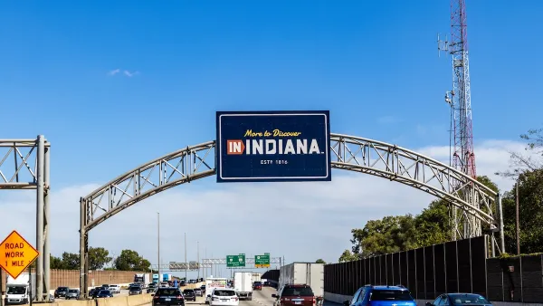 "More to Discover in Indiana" sign over freeway at state line entering Indiana.