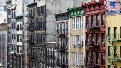 Colorful brick apartment buildings with fire escapes in Chinatown, New York City.