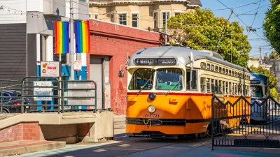 Orange and white vintage-look streetcar on Market Street in San Francisco, CA.