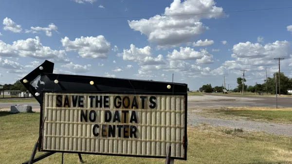 A sign in a field that reads "Save the goats, no data center"