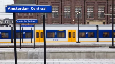 A local train is in motion on one of the platforms at the Amsterdaam Centraal train station.