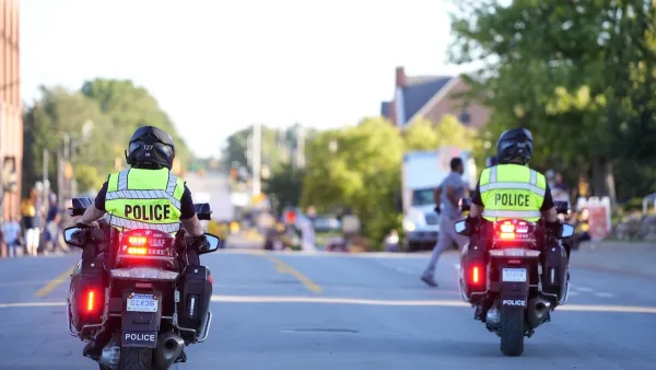 Two Ann Arbor police officers on motorcycles wearing bright yellow reflective vests with POLICE on back.