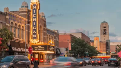 Cars are blurred as they pass the bright lights of the Michigan Theater at dusk in Ann Arbor.
