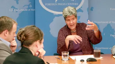 I picture of Marisa Lago speaking at a table for an event at the United Nations.