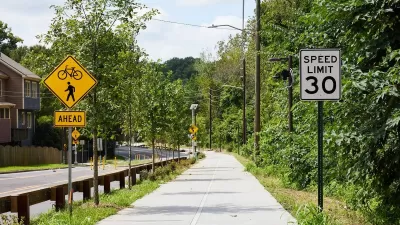 Paved Atlanta Beltline trail segment next to street with bike and pedestrian crossing sign and 30 mph speed limit sign.