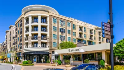 A mid-rise building with retail and apartments. A car port announces the name of the development: Avalon.