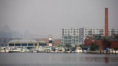 The city of Baltimore's Inner Harbor blanketed in fog, as seen from the water.