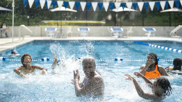 An older Black man and two Black children play in a newly-renovated Baltimore pool.