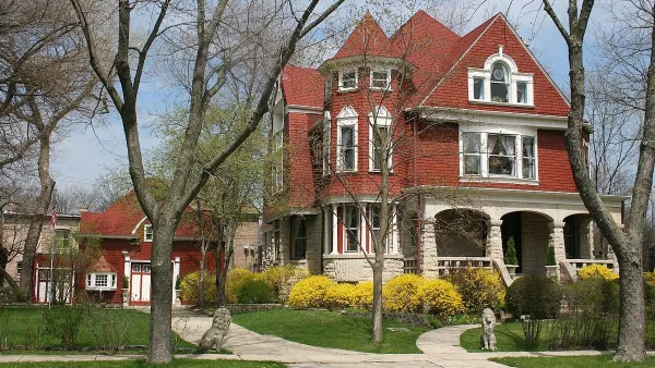 Red brick mansion with white trim in Chicago with small red brick coach house next to it.