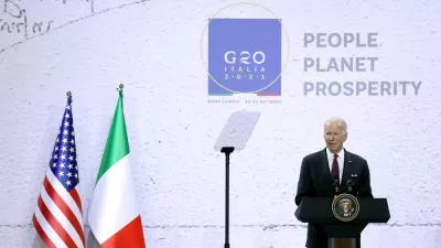 President Joe Biden speaks at a podium in front of flags from the United States and Italy at the 2021 G20 conference in Rome, Italy.