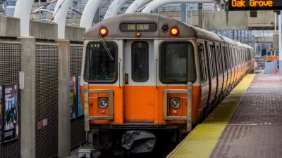 An MBTA Orange Line train bound for Oak Grove waits at a station.