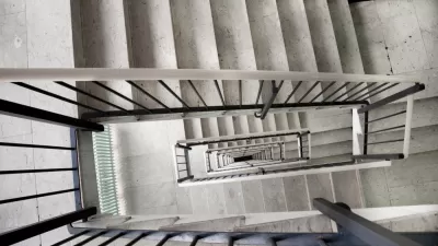 View looking down a multi-story apartment building staircase