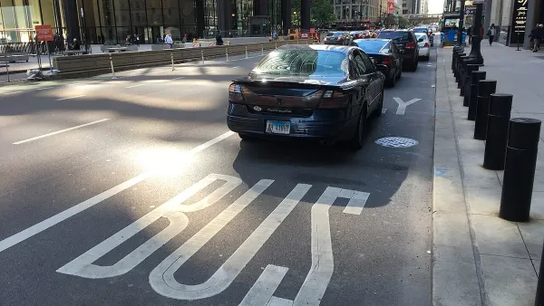 Multiple black cars parked in bus only lane in Chicago.