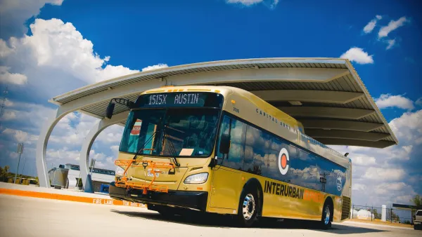 Yellow CARTS bus pulling out of covered parking bay.