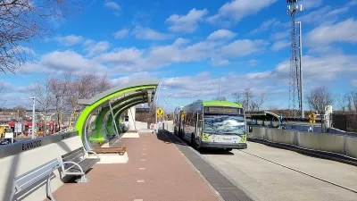 Green and silver CTfastrak bus at a station in Elmwood, Connecticut.