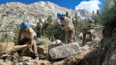 An Inyo Backcountry Trail Crew uses rock bars and other hand tools to build new trail out of rock.