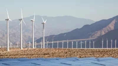 Wind turbines and solar panels against a backdrop of mountains in the Mojave Desert near Palm Springs, California