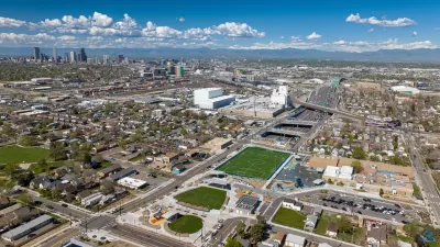 Aerial view of the cover park over I-70 and surrounding neighborhood with downtown Denver in background.