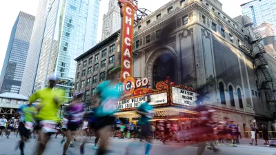 Runner passing the Chicago Theater are blurred as they pass by the camera for a race on the streets of Downtown Chicago.