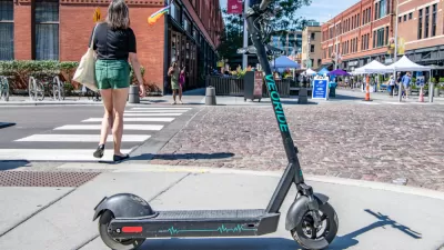 An electric scooter blocks the sidewalk near a street festival in Chicago's West Loop.