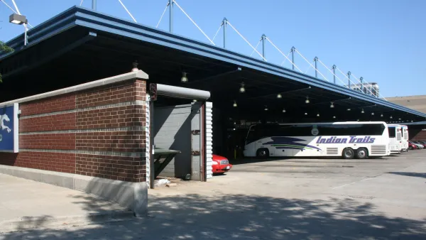 Covered bus parking at Chicago Greyhound station with two white intercity buses.