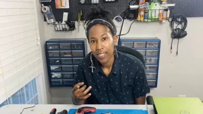 A Black woman works in a shop to prepare electronics for recycling..