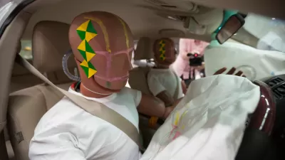 A pair of crash test dummies in a car after a crash with air bags deployed.
