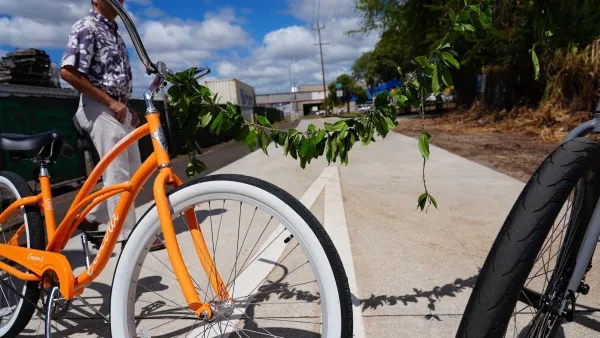 Close-up on orange cruiser bike decorated with garland of leaves on Pearl Harbor Bike Path.