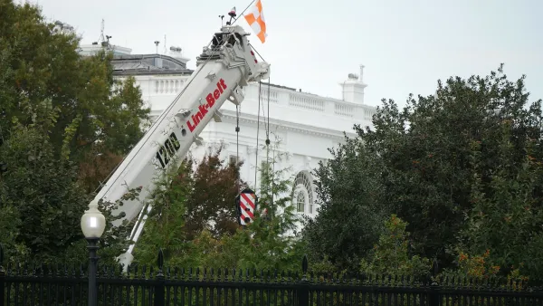 East Wing of White House with white demolition crane in front.