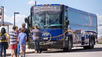 Passengers boarding a blue Flatiron Flyer BRT bus in Denver, Colorado.