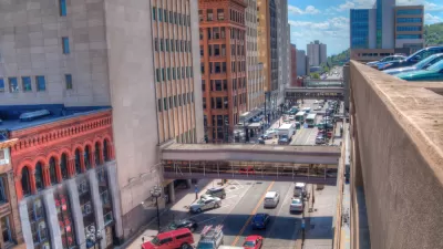 A busy street in Duluth, full of cars and buses.