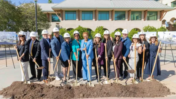 A crowd of people, including LA mayor Karen Bass, hold shovels to symbolize breaking ground on the light rail project.