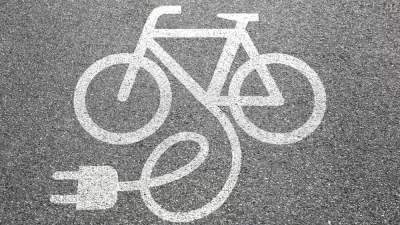Electric bike charging logo on asphalt