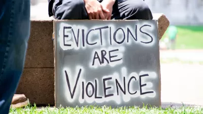 Person holding sign that says "Evictions are violence"