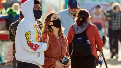 Two young people wear masks while standing outside in Florida.