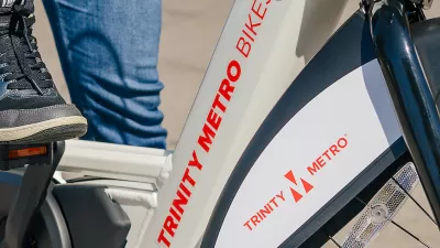 Close-up of person wearing Nike tennis shoe on Trinity Metro bike share e-bike.