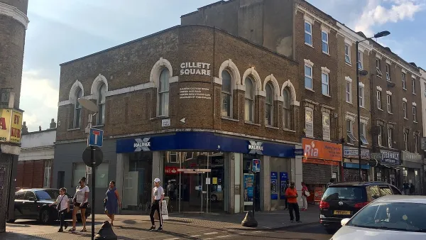 Intersection with sign for Gillett Square in East London, UK with brick buildings with ground floor storefronts.