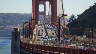 The Golden Gate bridge viewed from Marin, with cars passing in either direction on a sunny day.