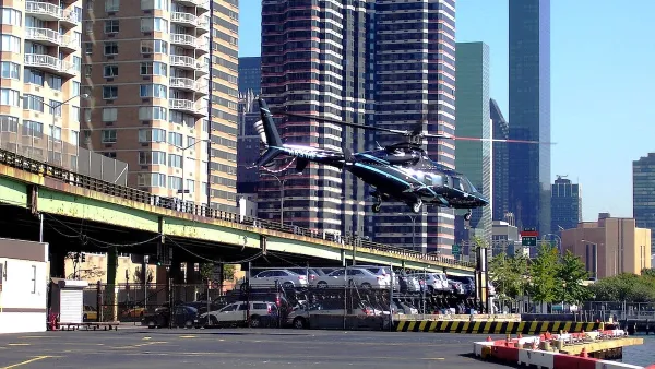 A helicopter taking off from a concrete helipad next to the East River in Manhattan.