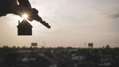 Hand holding house keys on house-shaped keychain