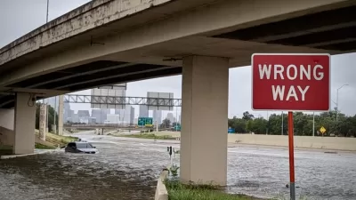 Flooded freeway underpass with red and white WRONG WAY sign in Houston, Texas during Hurricane Beryl in July 2024.