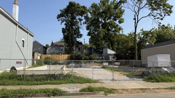 Vacant lot behind chain link fence in Covington, Kentucky.